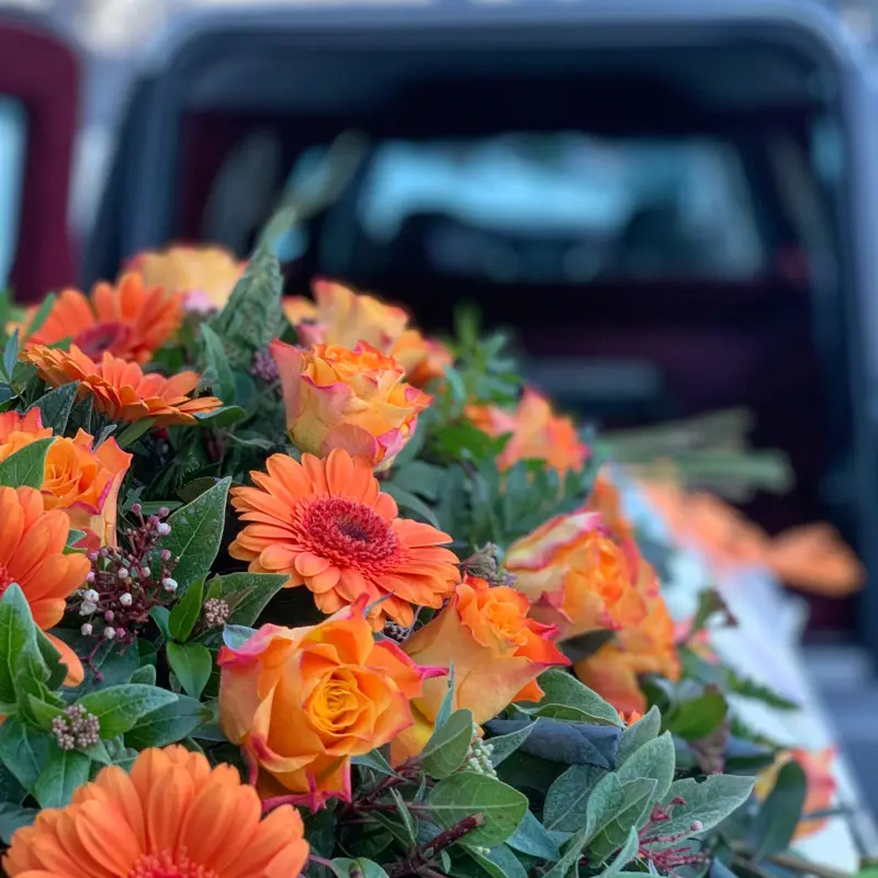 blomster på kiste i bårebil